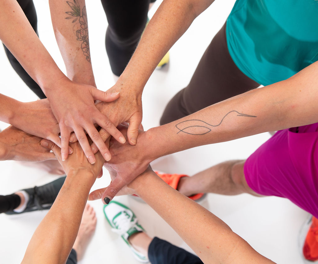 Members joining hands together after a class