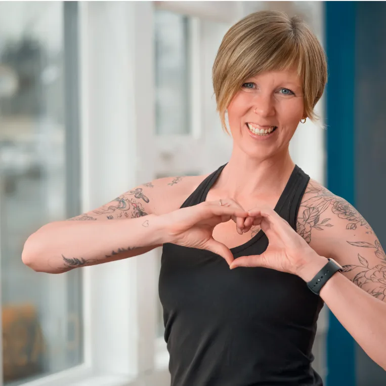 Studio IPF instructor smiling and making a heart shape with her hands